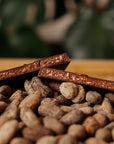 Tablette coupée en deux avec intérieur praliné noix de coco sur un fond de fèves de cacao.